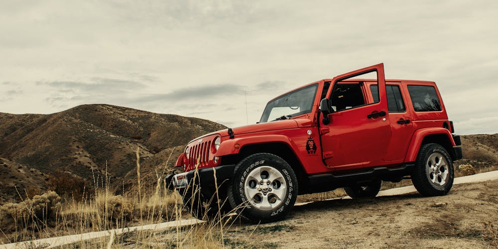 Red SUV on a scenic dirt road